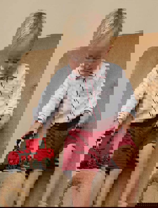 Baby boy wearing burgundy babycord short and white pique shirt set.