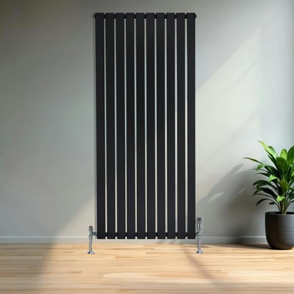 Flat black single column radiator, 1600mm x 700mm, featuring vertical slats and chrome valves, set against a modern interior with a plant