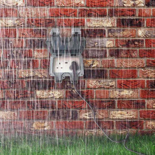 ENER-J IP65 waterproof outdoor socket mounted on brick wall during heavy rain