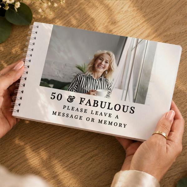 Hands holding the Personalised Photo Upload Guest Book featuring a portrait photo and 50 & Fabulous text by Abode Home & Gifts