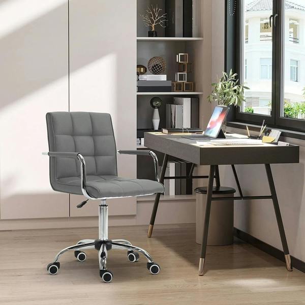 Grey mid-back office chair with armrests, chrome pedestal, and rolling casters in a workspace
