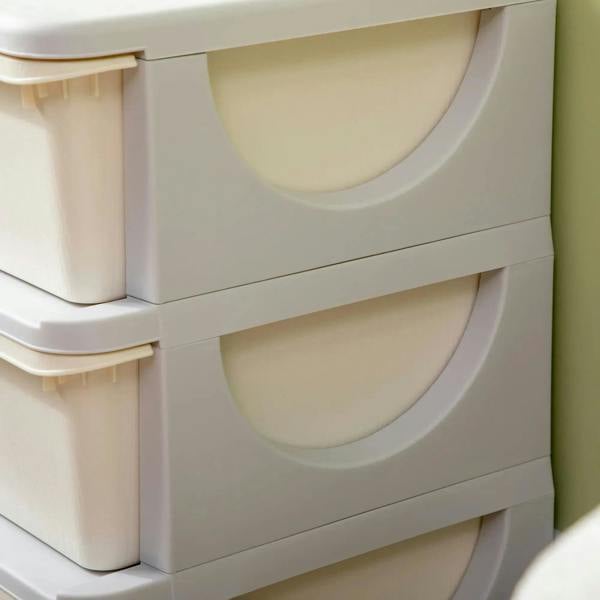 Close-up of cream drawer bins and gray frames with rounded handle cutouts