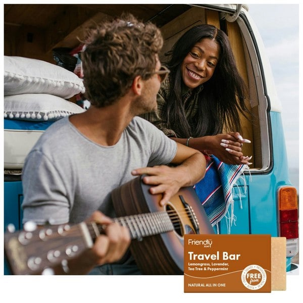 Young couple in camper van playing acoustic guitar