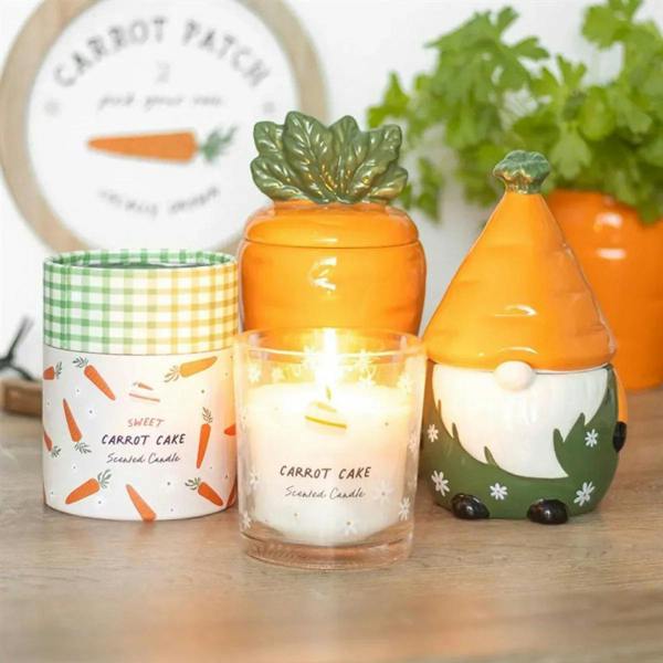 Lit carrot cake scented candle jar with green gingham lid and carrot label design
