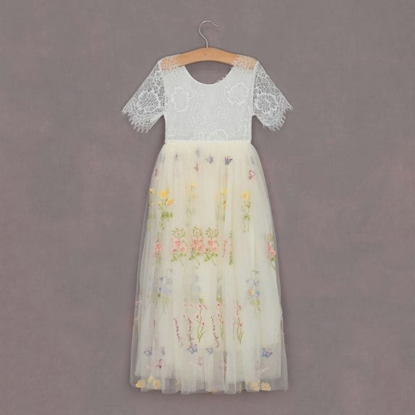 White lace top and floral tulle skirt on a hanger against a gray background