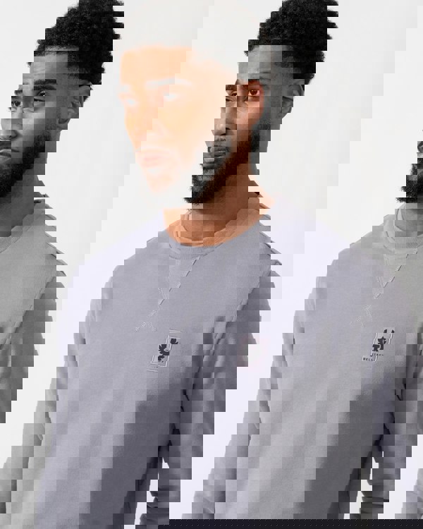 close up of a Model wearing a Belstaff Mens Crew Neck Sweatshirt With Logo Patch in Faded Indigo