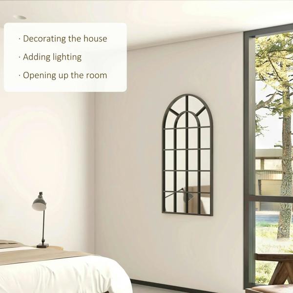 Black arched wall mirror with window grid design on a bedroom wall