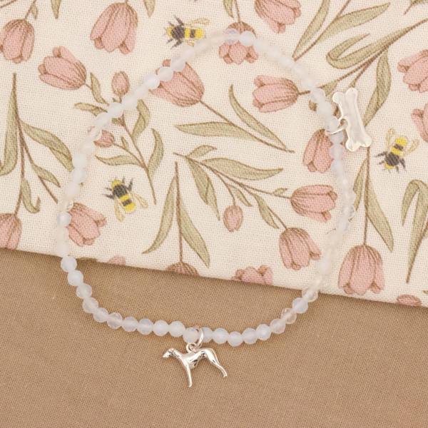Bracelet with a whippet charm on a floral fabric background
