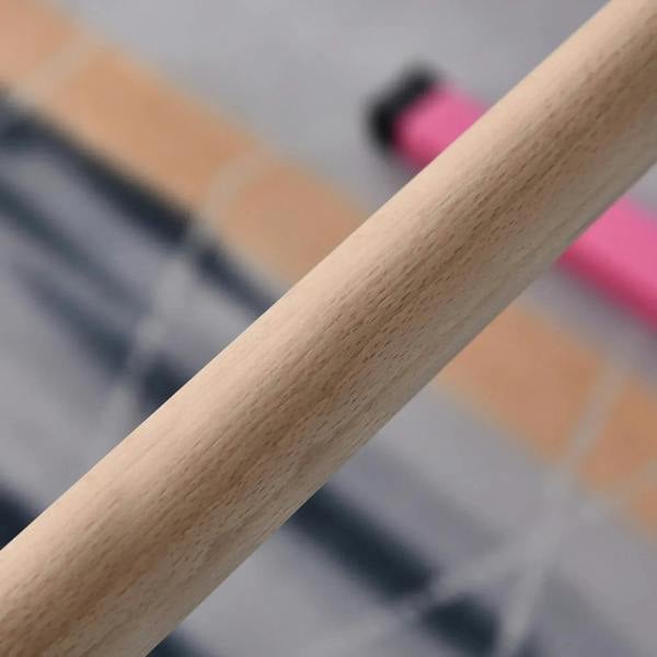 Close-up of light wood grip on a pink kids gymnastics horizontal bar