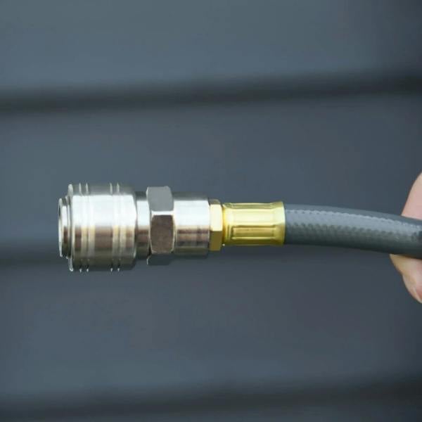 Close-up of air hose connector with brass fittings and grey hose