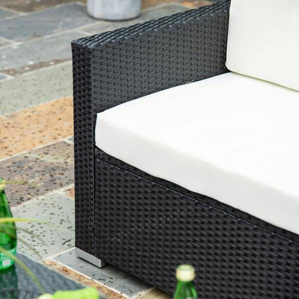 Black woven rattan armrest and cream cushion on a patio sofa