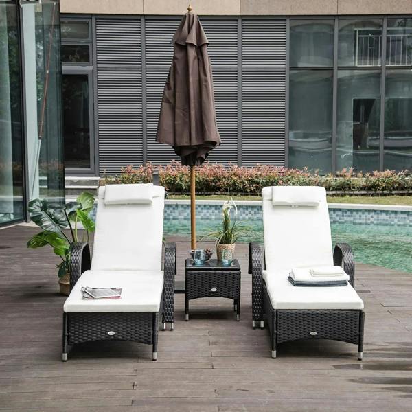 Black rattan sun lounger chairs with white cushions, patio by poolside