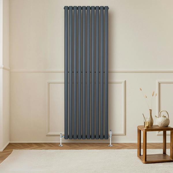 Anthracite grey oval single column radiator with vertical bars, mounted on a wall, enhancing a modern living room decor