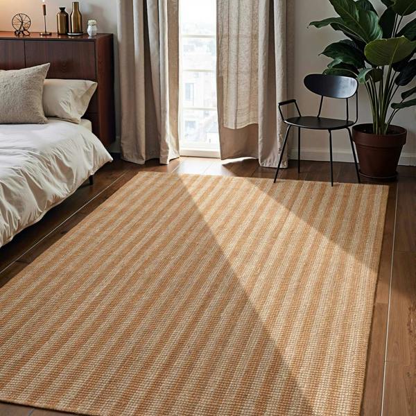 Striped rug in a bedroom with a bed, chair, and plant.