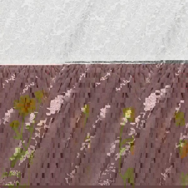 Embroidered floral pattern on a brown fabric against a textured white background