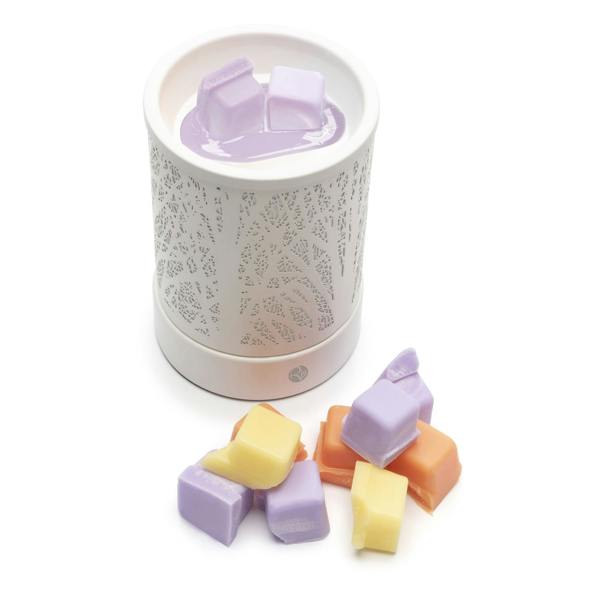 A white electric wax warmer with a lacy pattern melts Rio’s Scented Soy Wax Melts—Pack of 5 Fragrances—in rich purple, orange, and yellow blocks, ready to fill your space with inviting aroma.