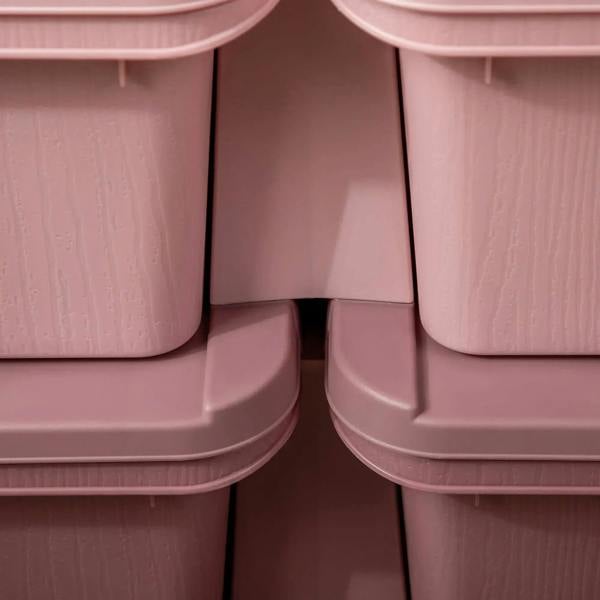 Close-up of pink six-drawer storage unit bin openings and molded corner supports