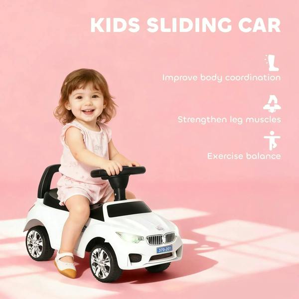 White kids sliding car with black steering handle and toddler seated