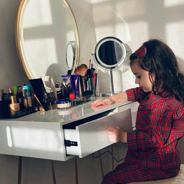 White vanity desk with LED mirror and acrylic top, child opening a drawer