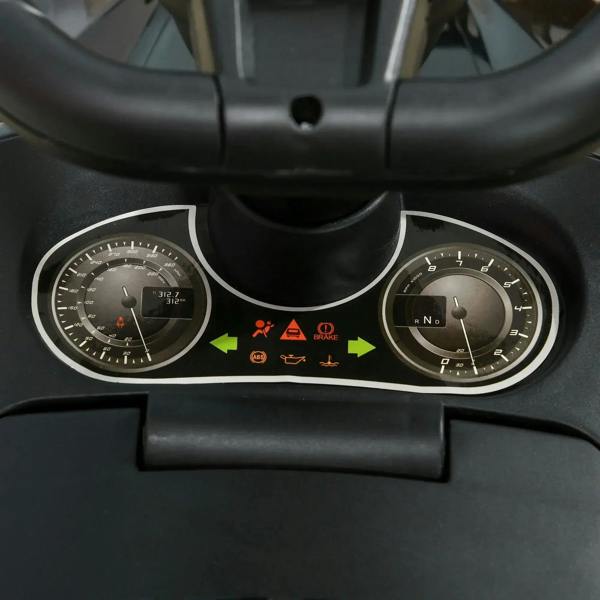 Close-up of black ride-on car dashboard with gauge dials and control buttons
