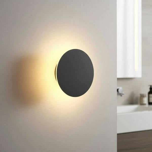 black bathroom sconce mounted on the wall in a modern bathroom