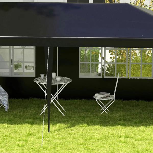 Black outdoor party tent gazebo close-up with window panels and two folding table sets