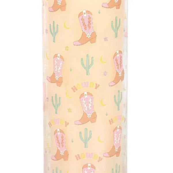 Close-up of pastel cowboy boot and cactus print on tube candle with 'Howdy' text