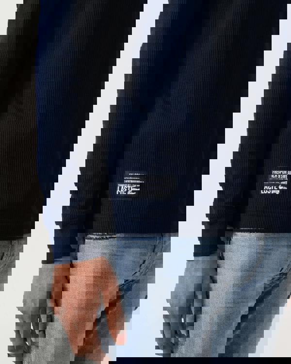 label detail of a Lacoste Boxy Tunisian Neck Mens Knit T-Shirt in Navy Blue 166