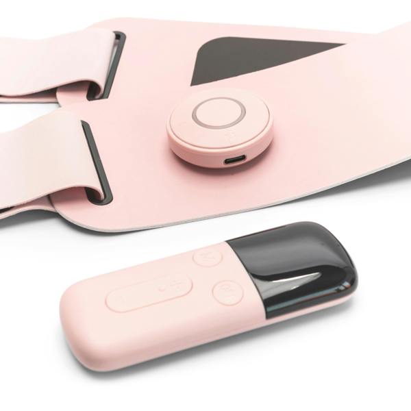 A close-up of the Ab, Tone & Shape EMS abdominal belt with a round button and matching remote, both on a white surface. This wearable device features black accents for muscle stimulation and ab toning.