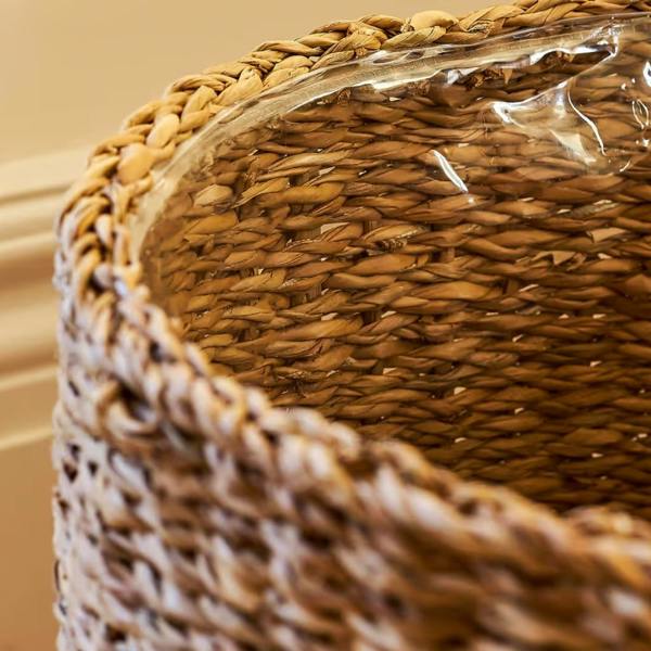 Macro shot looking inside the 48cm handwoven seagrass planter showing the clear plastic waterproof lining fitted along the inner weave.