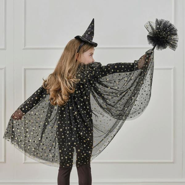 Back view of a child wearing a black tulle witch costume cape with gold foil stars and a matching witch hat headband.