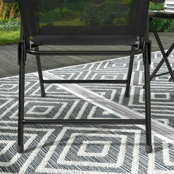 Black folding patio chair with mesh seat and legs over patterned outdoor rug