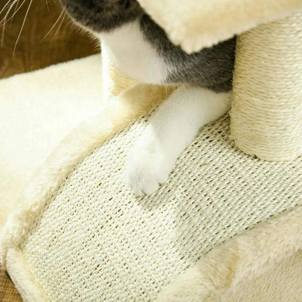 Cream plush scratching pad on a cat tree platform with a cat paw