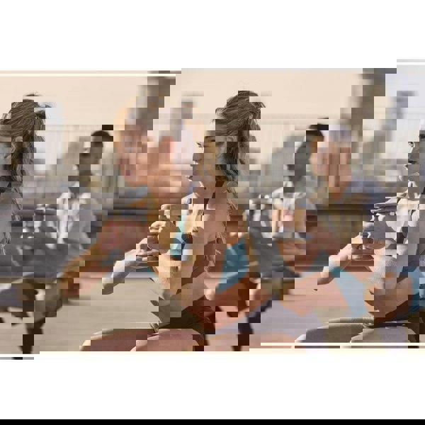 Man and woman performing squats holding Reebok 2kg Dumbbells