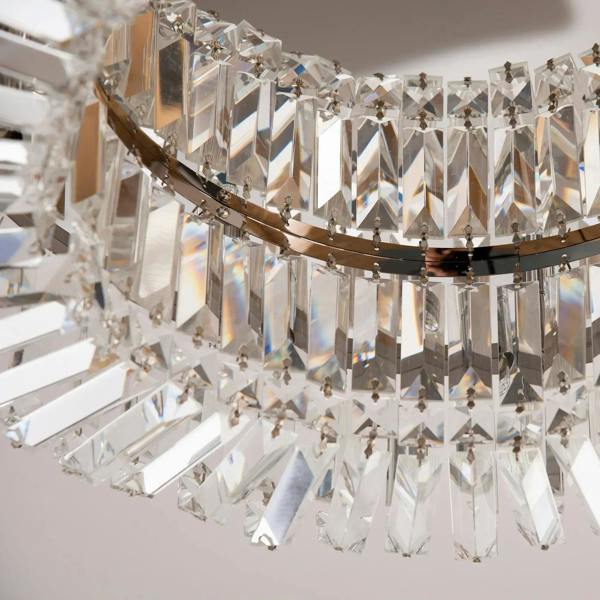 Detail of dangling crystal prisms and metal frame on a round silver ceiling light