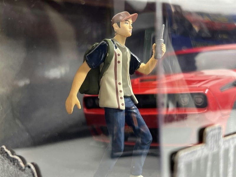 a toy figurine of a man holding a radio