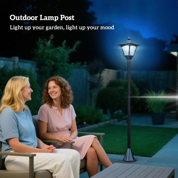Black outdoor solar lamp post with lantern head lit by patio walkway