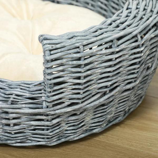 Close-up of grey wicker pet bed corner with beige cushion edge