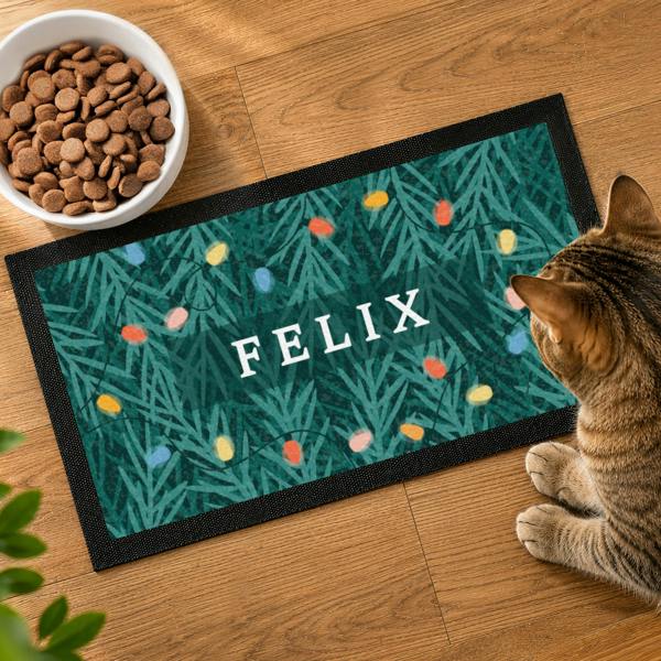 Top-down view of a personalised Christmas pet bowl mat featuring a retro fairy light pattern with the name FELIX.