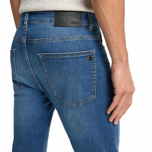 Back view of BOSS Delaware slim-fit blue jeans featuring a black leather logo patch and metal hardware on the pocket.