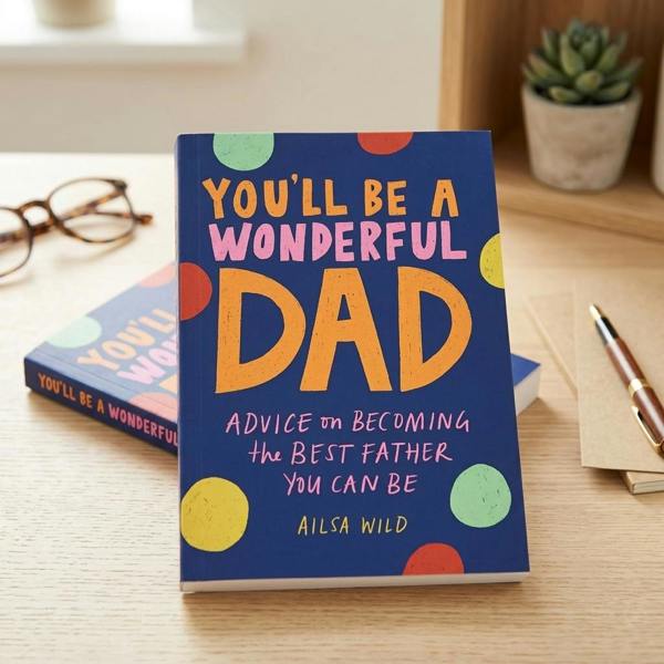 Abode Home & Gifts lifestyle display of the 'You'll Be a Wonderful Dad' hardback book standing on a wooden desk alongside a fountain pen and spectacles.