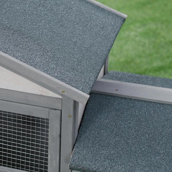 Grey double-tier rabbit hutch corner with textured roof and wire mesh door panels