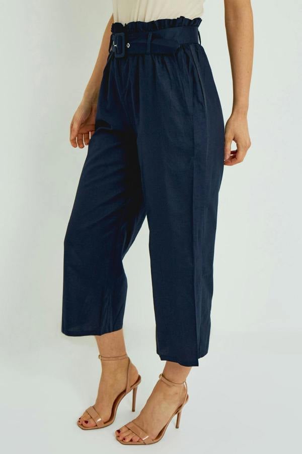 Navy blue paperbag waist pants worn by a person on a white background