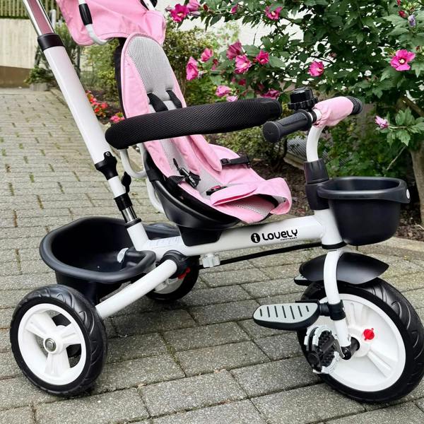 Pink baby tricycle stroller with black tray and armrests, side close-up
