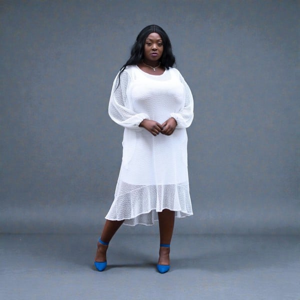 Women's Plus Size Aphrodite White Holiday Resort Dress with a white undergarment, paired with blue heels for a chic holiday look.