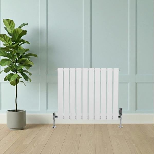 Flat single column radiator in white, 600mm x 700mm, featuring sleek vertical fins and chrome valves, set against a light wall and wooden floor
