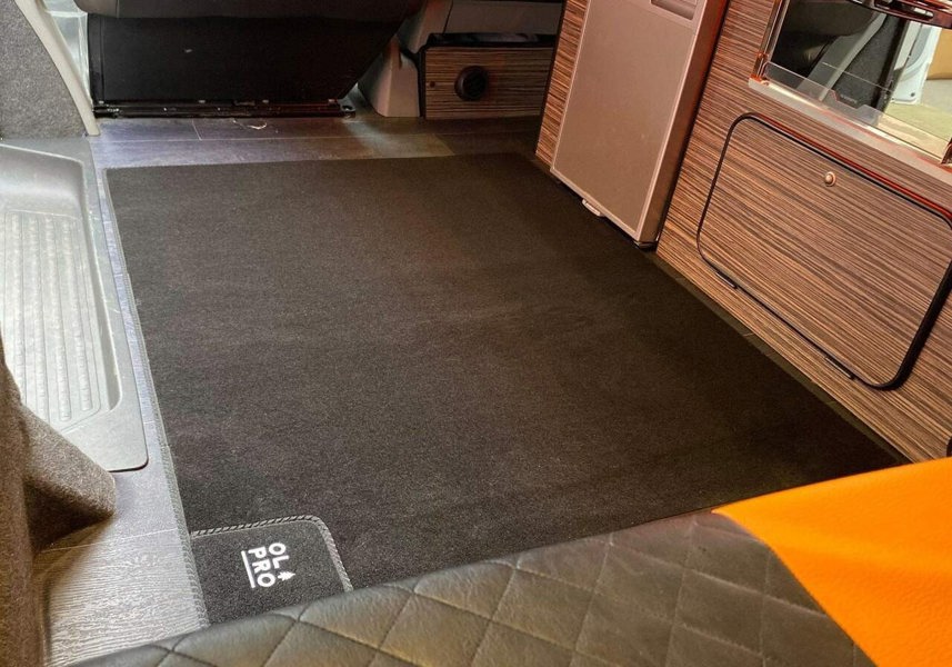 The OLPRO Rear Campervan Living Area Carpet - 1000mm x 1000mm being used in the living section of a campervan awning.