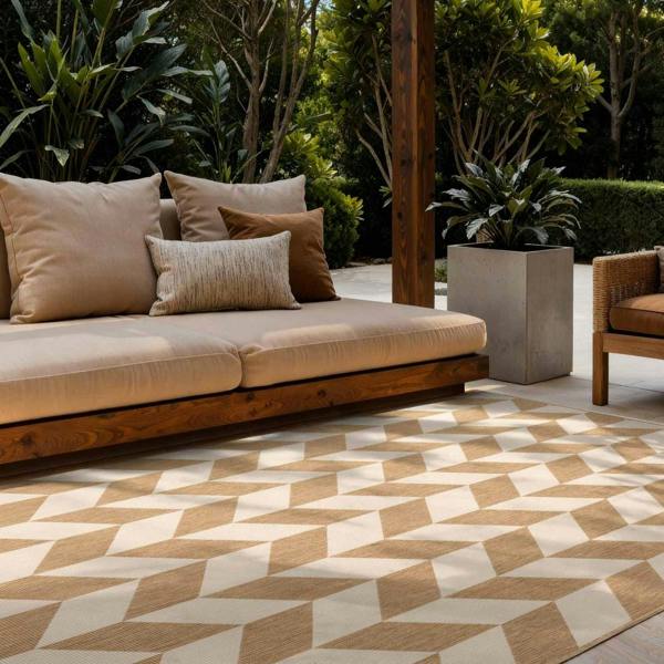 Outdoor seating area with a geometric patterned rug, cushions, and plants.