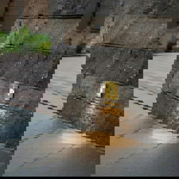 brass decking ground light recessed into a stone wall outside