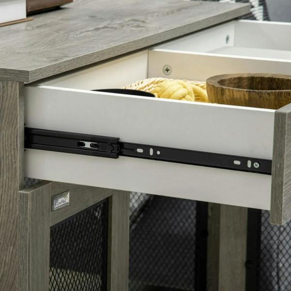 Open drawer and storage area under grey dog crate end table; rail and mesh base.